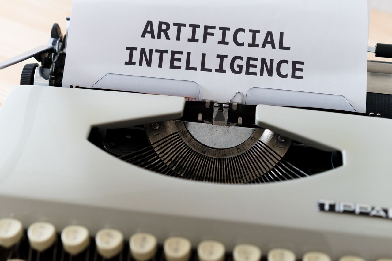 Services A close-up of a typewriter showcasing 'ARTIFICIAL INTELLIGENCE' on paper.